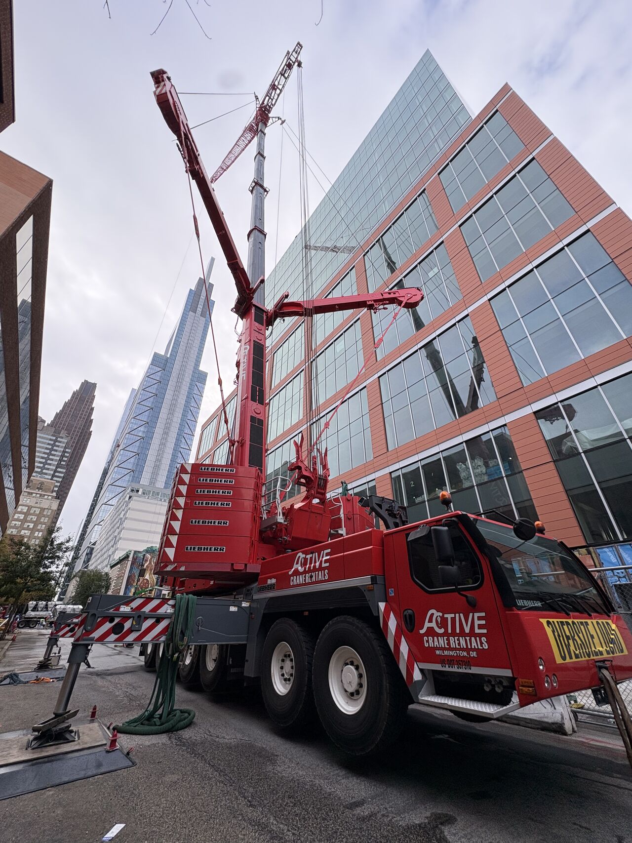 Red crane with booms extended in downtown city